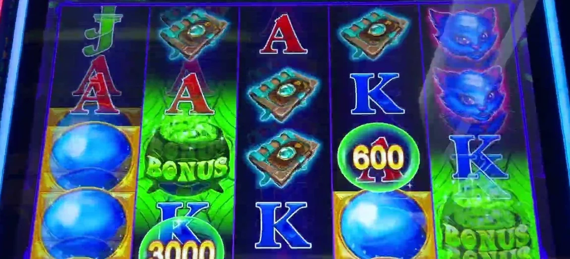 Read every bubble on the glass and add the printed values: a high-value 3000 bubble at the bottom, a 600 to the right, plus blue carry-over bubbles stacked on the outer reels. Add only the bubbles that are NOT on the top row — those leave next spin. Total the survivors against 5× your bet.