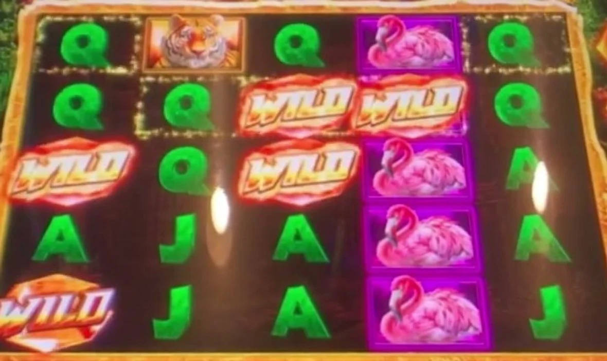 The trigger, printed on the glass: two yellow flaming WILD WILD symbols sitting adjacent on the same row across reels 3 and 4 — wilds already lined up to pay as the whole board slides one position left next spin. Extra wilds stacked on the left reel sweeten it. That same-row pairing, or six-plus wilds anywhere, is the state you sit down for.