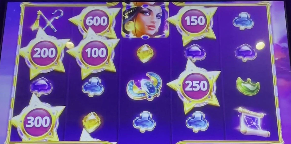 The read in one glance: six gold star-shaped frames scattered across the reels — 200, 600, 100, 300, 150, 250 — every one of them sitting below the top row, each carrying a credit value it can drop onto. Two or more of these frames anywhere but the top row is the whole play.