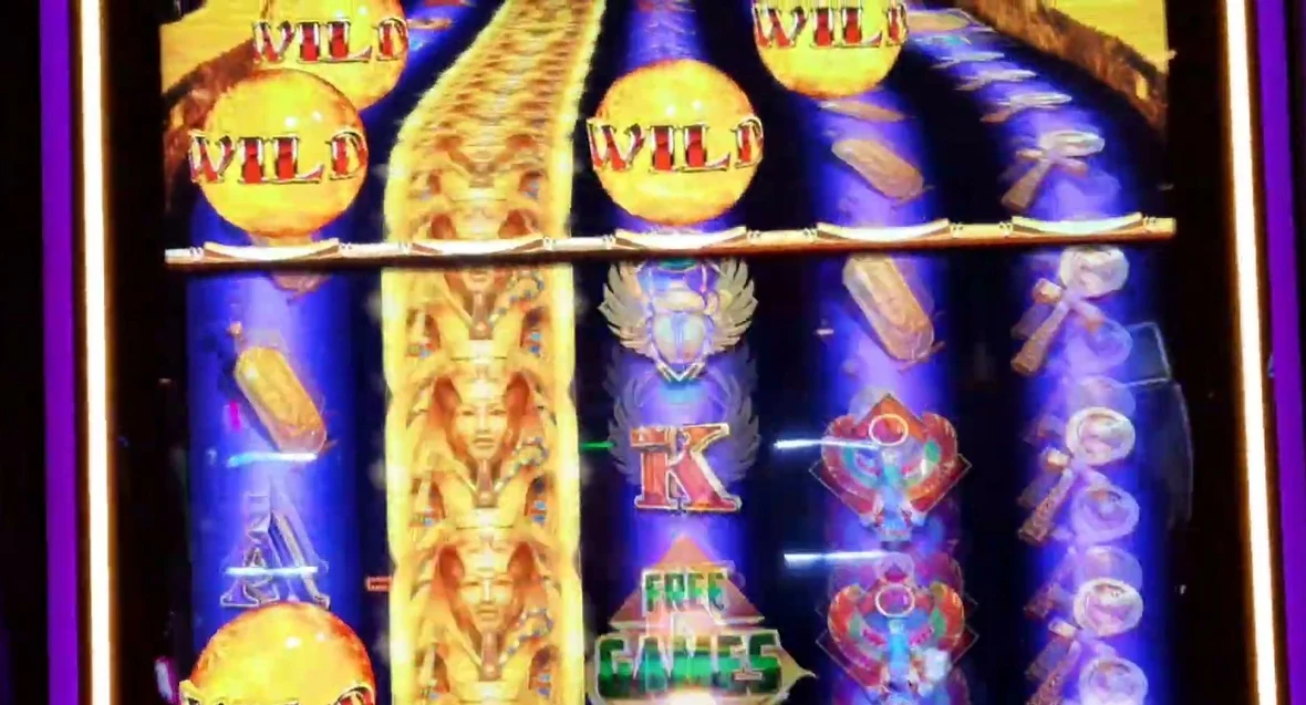 Three WILD boulders stacked in the upcoming queue on the golden ramp above reels 1-3, with another already dropping into the active area below. The gold bar splits the preview queue (top) from the live reels (bottom) — you can see the wilds coming before they ever play.