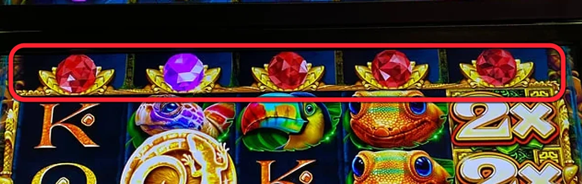 The active row, ringed: walk that one line of jewels directly above the reels left to right and count the reds. Here it's four reds and a lone purple — four is the play. That single row is the whole decision.