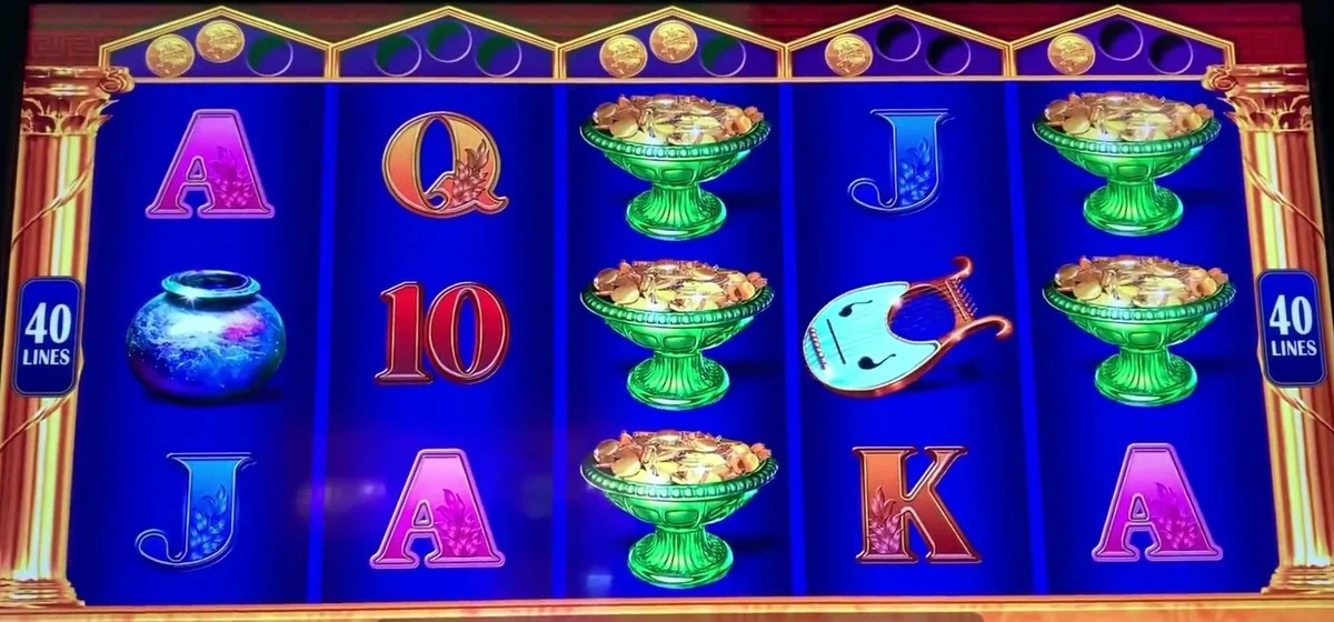 The read in one glance: coins banked in the slots above the reels — two over the first reel, two over the third, one over the fifth — with the green messenger pots feeding more in. Count the coins above the reels, not the symbols on them.
