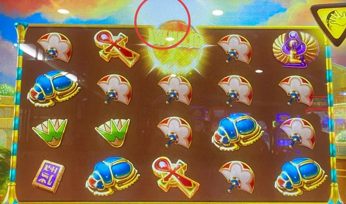 The play, frozen: a column of wild spheres sits in reel 4 with the gold lion parked in reel 3. A sphere above the bottom row still has room to drop onto that lion and detonate.