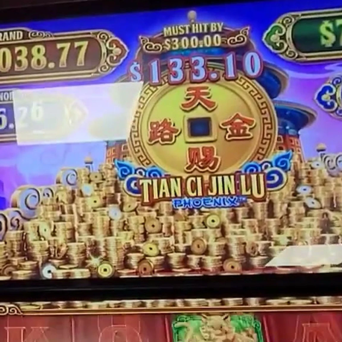 The live read: the MUST HIT BY $300.00 counter sitting right above the big gold coin in the middle of the screen, here showing $133.10. That single number above the coin is the whole play — when it climbs into the $292 zone you sit, and the four named jackpots around it (GRAND / MAJOR / MINOR / MINI) are noise.